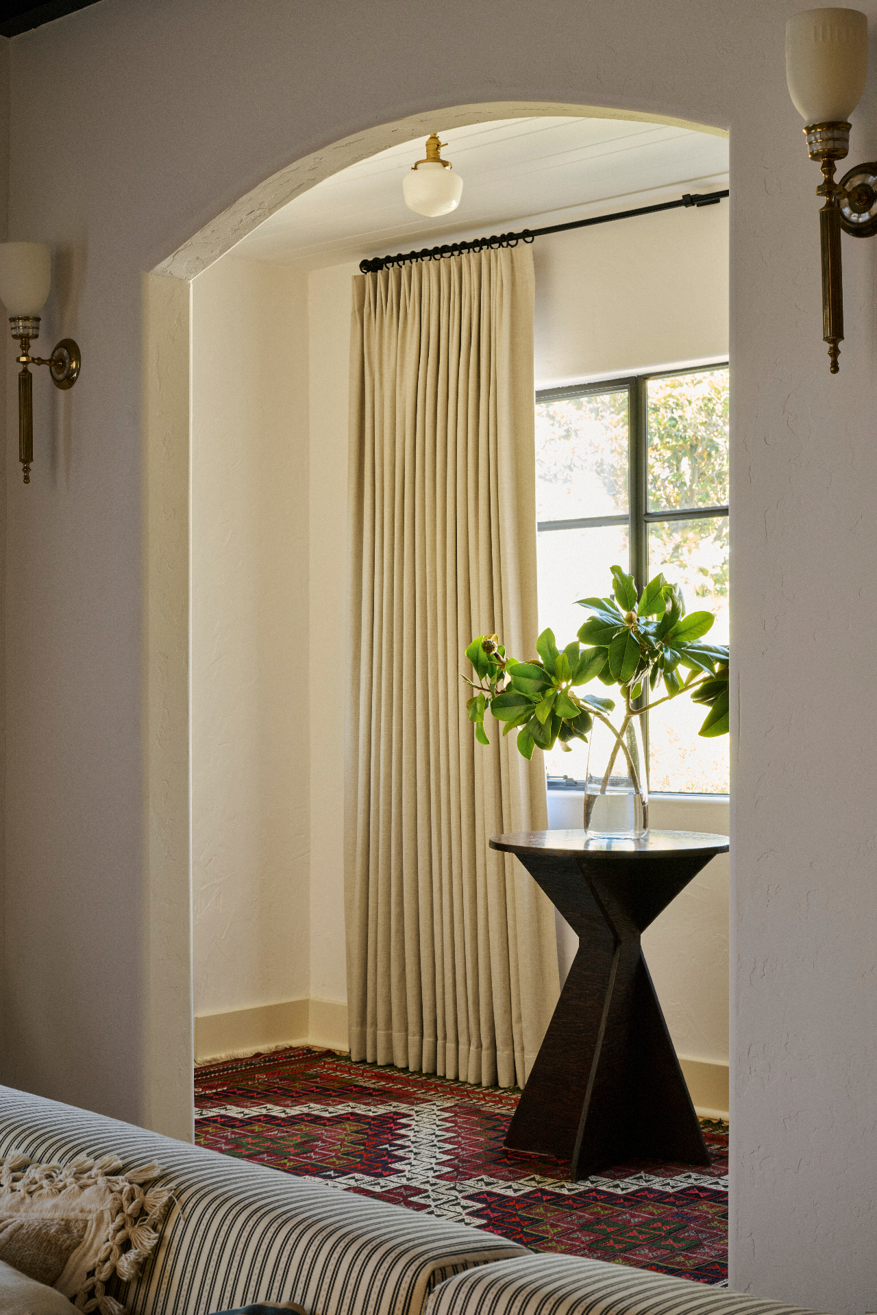 Tailored drapery panel in a light-filled archway