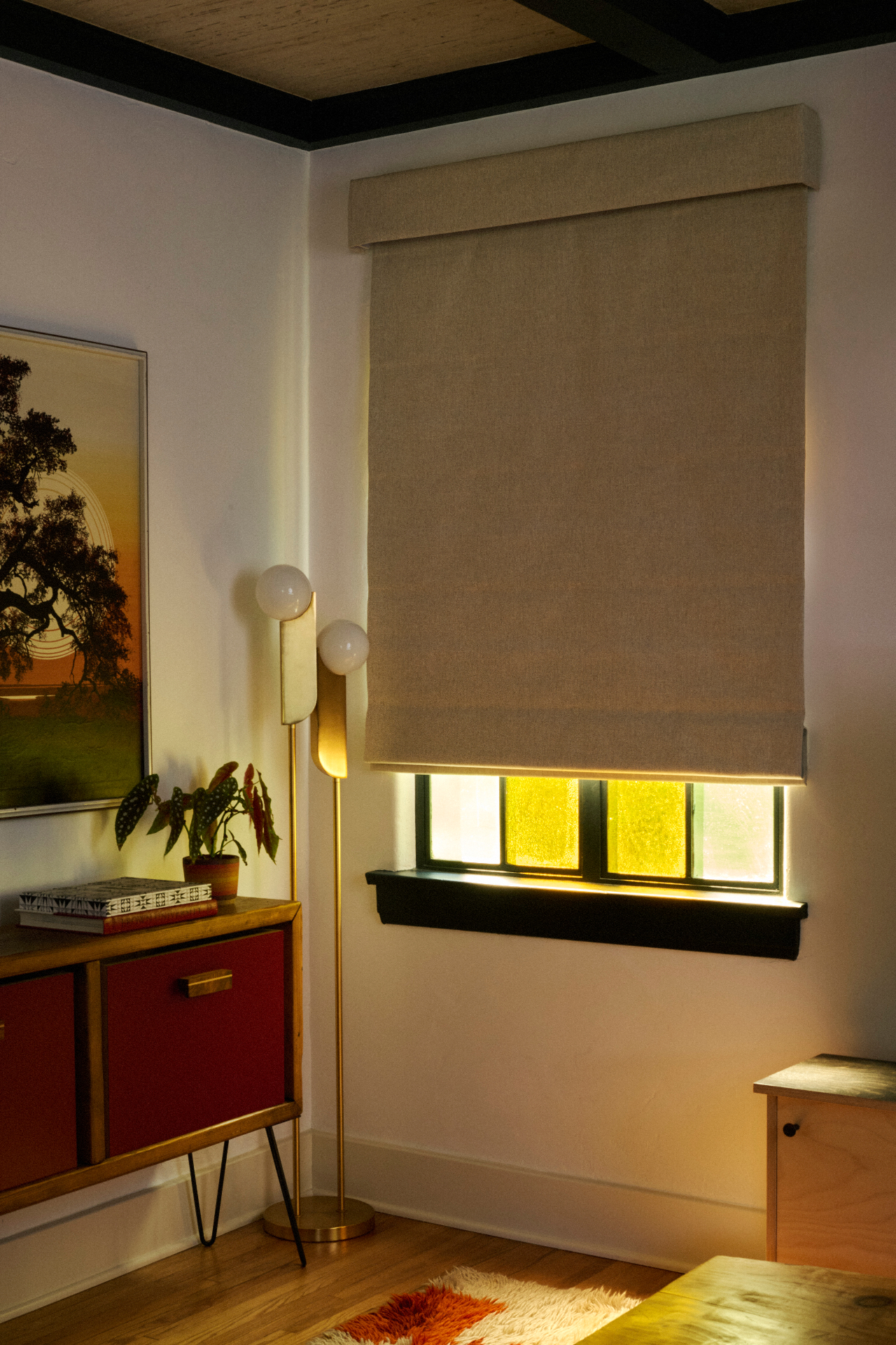 Neutral Roman shade in a styled interior with art and floor lamp